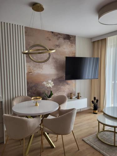 een eetkamer met een witte tafel en stoelen bij Apartament Jagiełly in Olsztynek