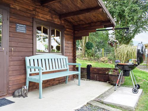 un banc bleu assis à l'extérieur d'une maison avec un grill dans l'établissement Alpaca Hideaway - Uk35188, à Newtown