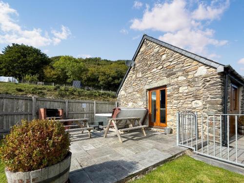 a stone cottage with a bench and a table at The Dairy -Uk50616 in Cynwyd