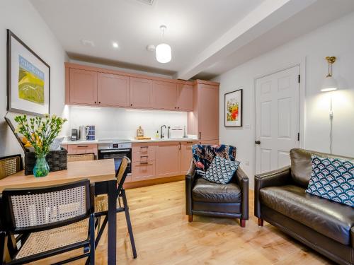 una cucina e un soggiorno con un tavolo e un divano di The Colleys a Lechlade