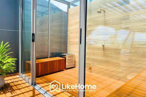 a glass door of a room with a wooden floor at Setai Aquamaris - LikeHome Hospedagens in Tambaú