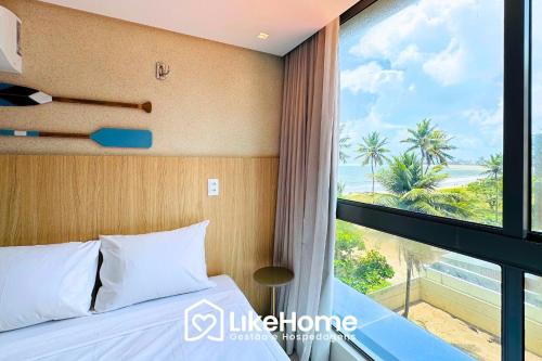 a bedroom with a bed and a large window at Setai Aquamaris - LikeHome Hospedagens in Tambaú