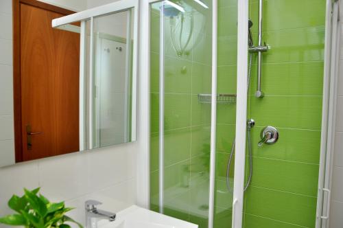 a bathroom with a shower with a sink and a mirror at Residence Itaca in Bibione