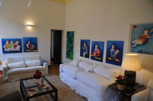 a living room with a white couch and pictures on the wall at Alberto Charming Home in Montepulciano