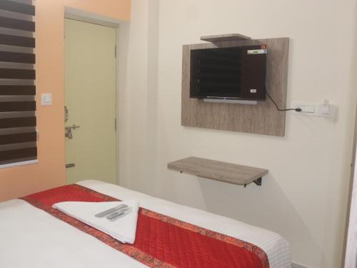 een slaapkamer met een bed en een tv aan de muur bij Redfox in Chennai