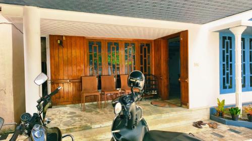 un scooter garé sur une terrasse avec une maison dans l'établissement Lake and Paddy holiday home, à Alappuzha