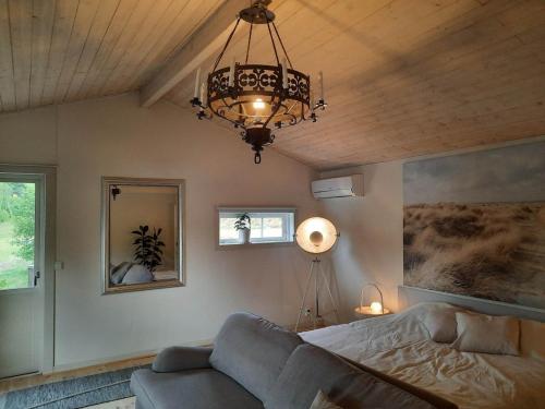 a living room with a couch and a chandelier at The old henhouse in Tenhult