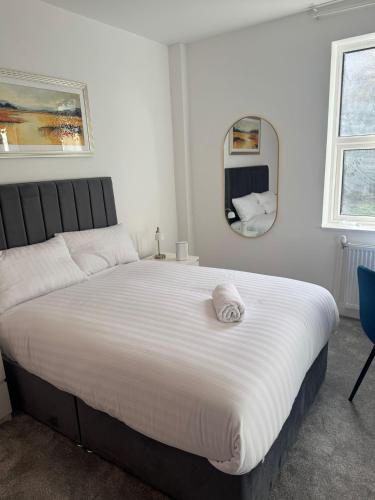a bedroom with a large white bed with a mirror at Kingfield Boutique Hotel in Sheffield