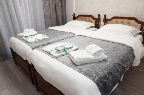 two beds with towels and glasses on top of them at Hotel Kochana in Chʼkhorotsqu