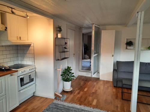 a kitchen with a stove and a couch in a room at The old henhouse in Tenhult