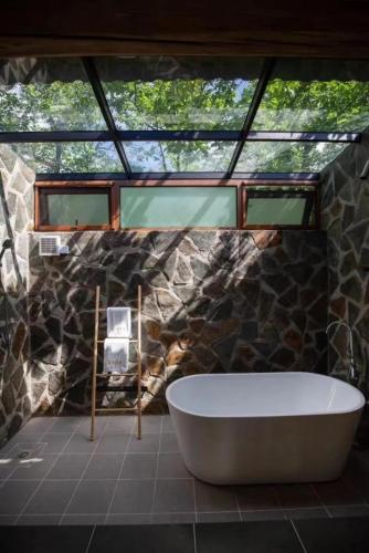 a bathroom with a large tub and a window at 北京丛林里野奢汤泉酒店 in Huairou