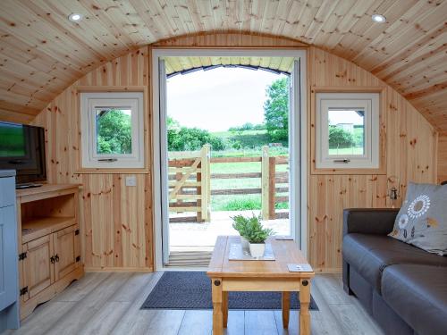a living room with a couch and a table at Glamping Pod 1 in Ipplepen