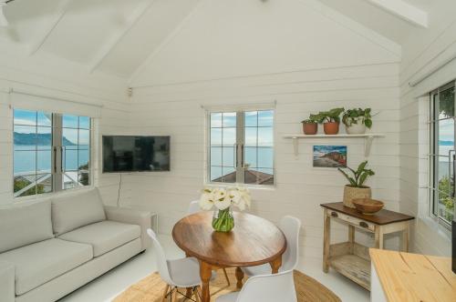 ein Wohnzimmer mit Tisch und Couch in der Unterkunft Oceanside Cottage in Rocklands