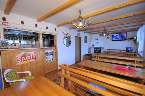 a restaurant with wooden benches and a bar at Penzion Dreveník in Spišské Podhradie