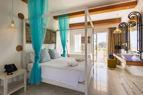 a bedroom with a bed with blue curtains and a bathroom at Lindos View Hotel in Líndos