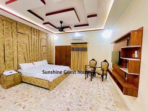 a bedroom with a bed and a table and chairs at Sunshine Guest House in Dargai