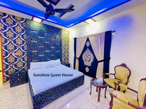 a guest house bedroom with a bed and a chair at Sunshine Guest House in Dargai