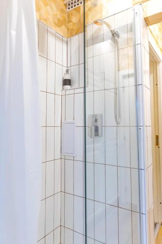 a bathroom with a shower with white tiles at Stepin in Kiskunfélegyháza
