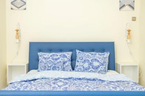 a bed with a blue headboard and pillows at Stepin in Kiskunfélegyháza