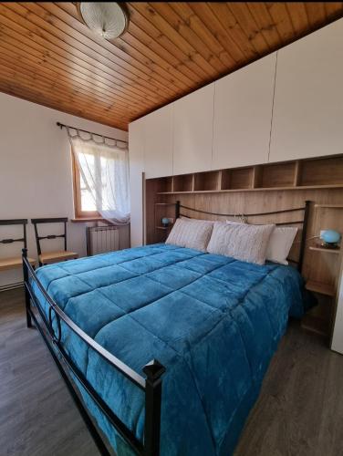 a bedroom with a large blue bed with a wooden ceiling at Le 4 oche in Bastia