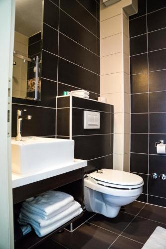 a bathroom with a toilet and a sink at Hotel Kapetanovina in Mostar