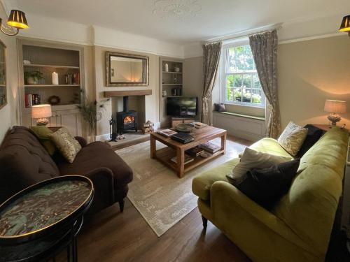 a living room with two couches and a fireplace at Honey Cottage in Gargrave