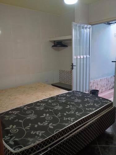 Cette chambre comprend un lit avec une couverture noire et blanche. dans l'établissement Casa com cozinha americana, à Araruama