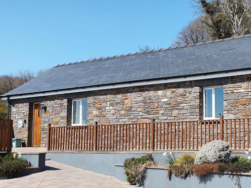a stone house with a bench in front of it at Beudy-Oh2 in Dihewid