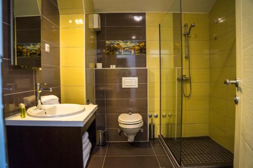 a bathroom with a sink and a toilet and a shower at Hotel Kapetanovina in Mostar