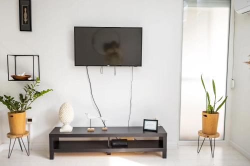 a living room with a tv on a white wall at Come.in in Kiskunfélegyháza