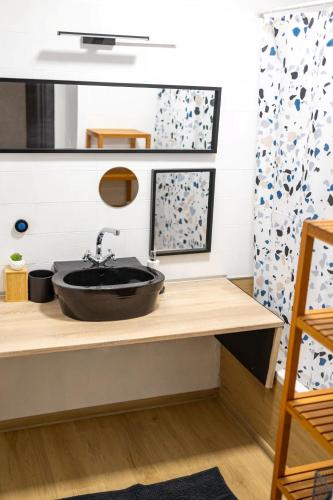 a bathroom with a black sink on a counter at Come.in in Kiskunfélegyháza