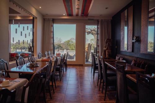 a dining room with tables and chairs and a window at Los Muelles Boutique Hotel in Carmelo