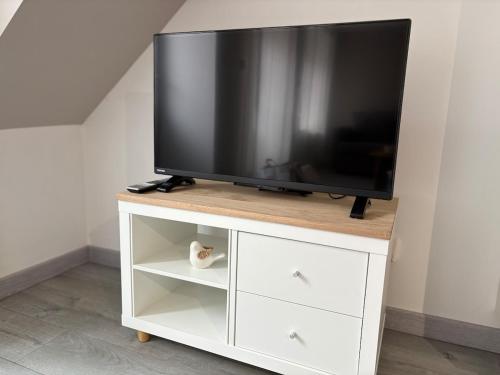 a flat screen tv on a white entertainment center at Cléanounette du Morvan in Saulieu