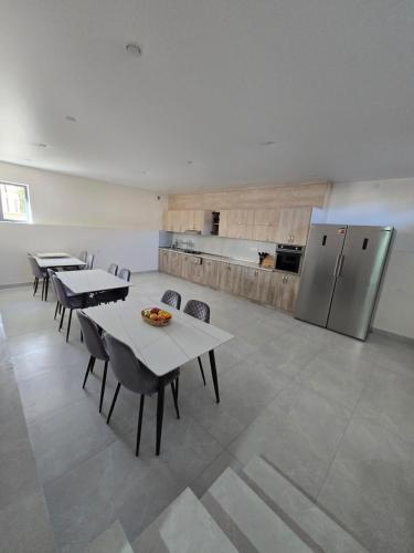a kitchen with tables and chairs and a refrigerator at Ultra Energy Hotel in Yeghegnadzor