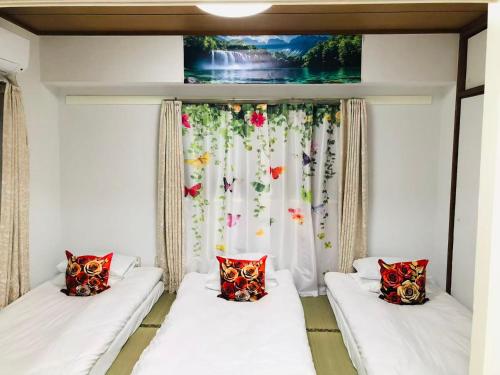 two beds in a room with a window at Ikebukuro-hostel池袋中川301&501-TS0038 in Tokyo