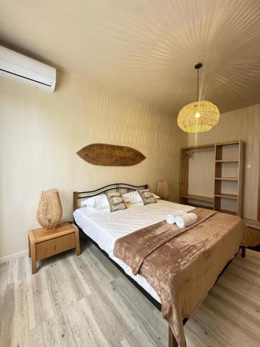 a bedroom with a large bed and a chandelier at Les Hauteurs de Brûlée in Rodrigues Island