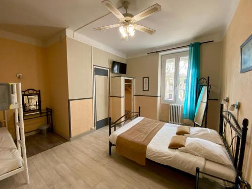 una camera da letto con un letto e un ventilatore a soffitto di Au Royal Hotel a Carcassonne