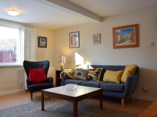 a living room with a couch and two chairs at Bruich Cottage in Newtonmore
