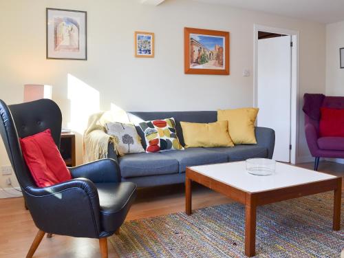 a living room with a blue couch and a coffee table at Bruich Cottage in Newtonmore