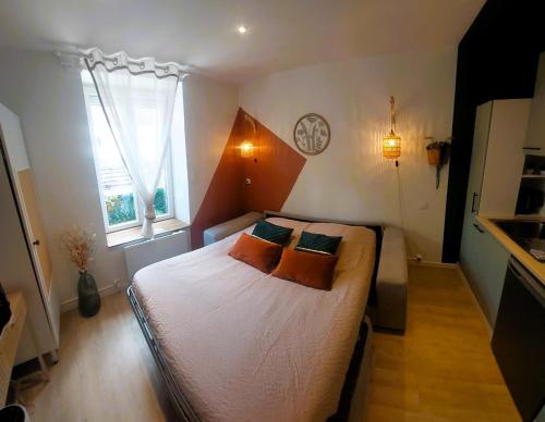 a bedroom with a bed and a clock on the wall at Le Cocon d'Anna - Le studio in Dole