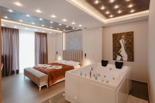 une chambre avec un lit et une baignoire dans une pièce dans l'établissement Elba Luxury Hotel, à Polisi i Vogël