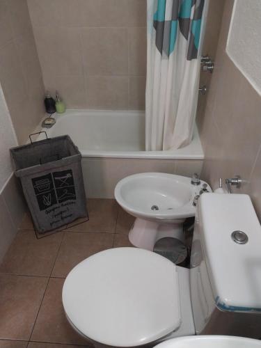 a bathroom with a toilet and a sink and a tub at Pichincha departamento in Rosario