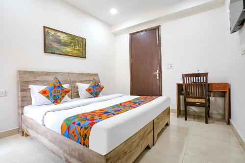 a bedroom with a bed with a desk and a chair at Via Premium Room I in New Delhi