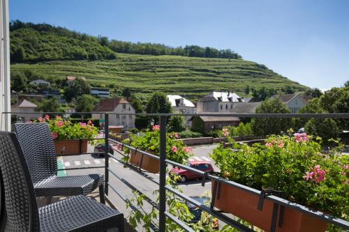 a view from the balcony of a house with flowers at The Originals City Hotel de l Ange Guebwiller in Guebwiller