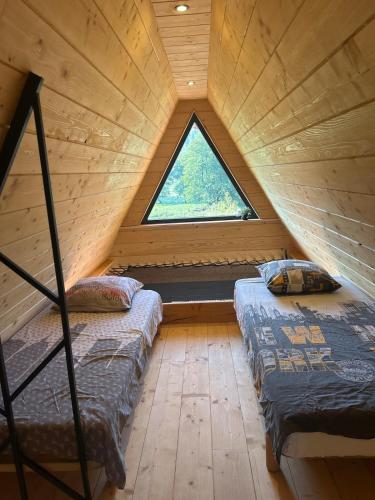 two beds in a attic room with a window at L Atypique in Saint-Éloi