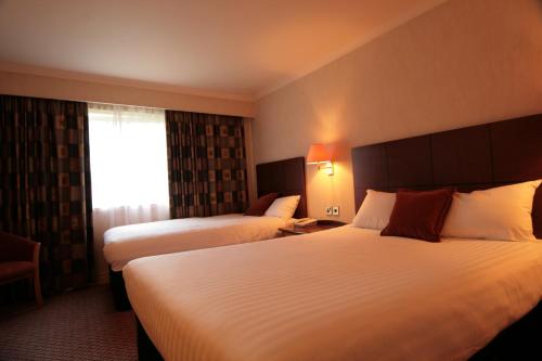 a hotel room with two beds and a window at Mercure Tunbridge Wells Hotel in Royal Tunbridge Wells