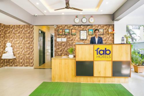 a man standing at a podium in a hotel lobby at FabHotel Saffron Inn I - Nr Darshan Museum in Pune