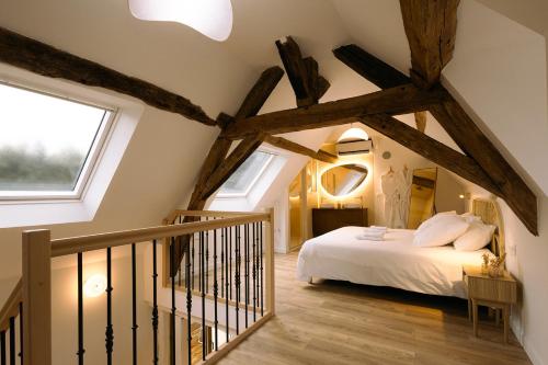 a attic bedroom with a bed and a window at Les Eclats d'Amour in Chargé