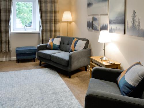 a living room with a couch and a chair at Blackmill Cottages No 2 in Taynuilt