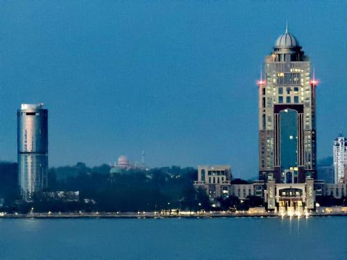 a city skyline with buildings in the water at night at Seaview Cozy BS Homestay in Kota Kinabalu